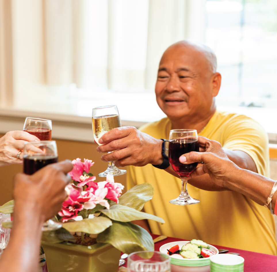 asian man cheersing wine glass with women