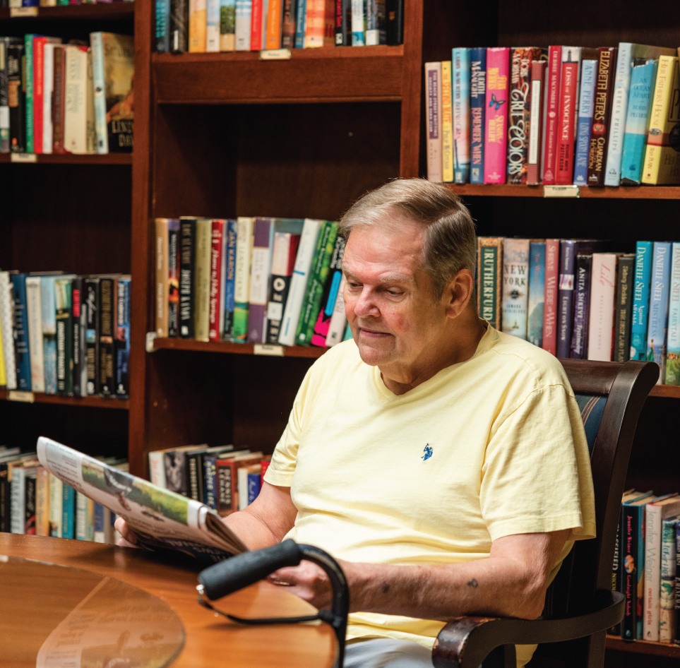 senior man reading in library