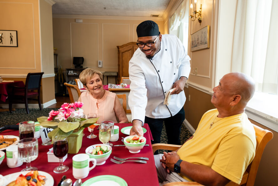 employee serving food to seniors