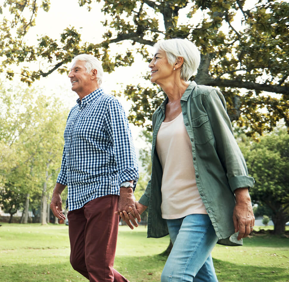 senior couple walking through the park