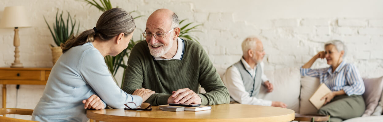 Senior friends sit around a table and have a conversation