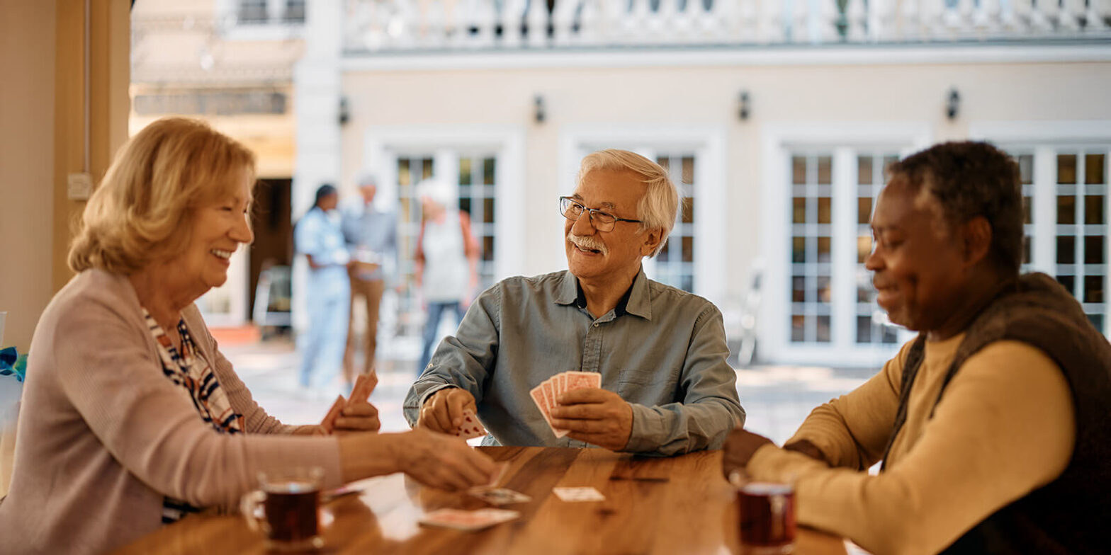 Senior friends playing poker around a table